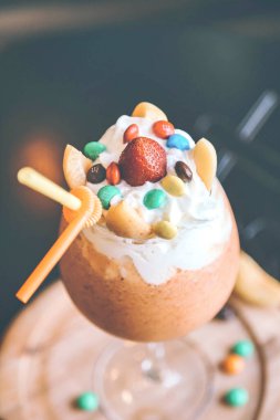 Ağız sulandıran bir tatlı içinde şekerli bir pipet ve üst tarafı süsleyen renkli şekerler..