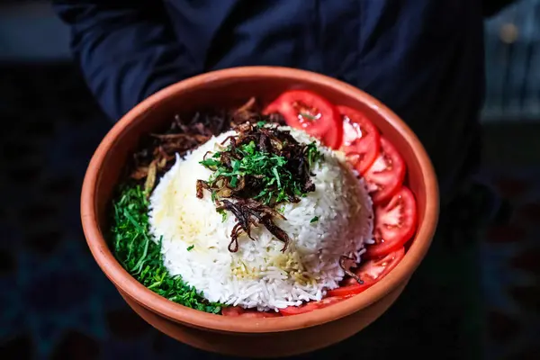 stock image A bowl filled with a vibrant mix of rice, tomatoes, and an assortment of fresh and nutritious vegetables.