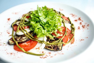 Beyaz tabakta bol miktarda taze marul yaprağı bulunan bir salata var..