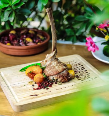 Ahşap kesim tahtası lezzetli bir yemeğe hazırlanmak için çeşitli et ve sebzeler sunar..