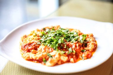 Beyaz tabak zarif ve görsel olarak çekici bir makarna tabağıyla kaplıdır..