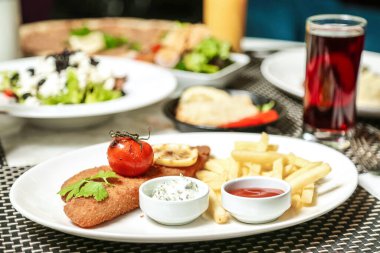 Ağzına kadar aperatifler, ana yemekler ve tatlılar dahil çeşitli ağız sulandırıcı yiyeceklerle dolu beyaz bir tabak..