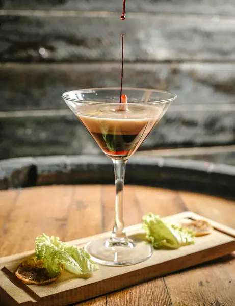 Stock image A glass filled with liquid placed on top of a sturdy wooden table.