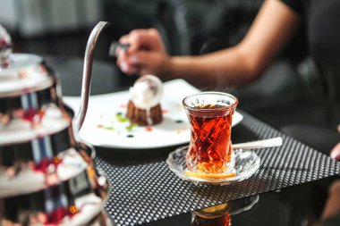 Tabaklar dolusu yemek ve çay da dahil çeşitli yemek ve içeceklerle dolu bir masa..