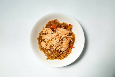 Masanın üstünde içi yiyecek dolu beyaz bir kâse resmi var..