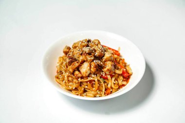 Lezzetli erişte ve lezzetli etle dolu beyaz bir kasenin yakın plan fotoğrafı..