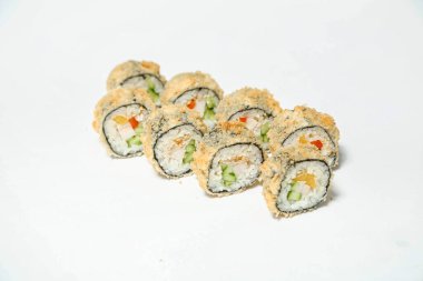 Bir grup suşi düzgün bir şekilde beyaz bir masanın üstüne dizilmiş..