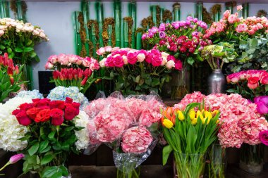 Çiçekçide gül, lale, ortanca ve zambaklardan oluşan çeşitli renkli çiçek buketleri sergilenmektedir..