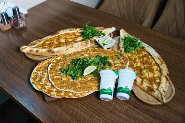 Lokantadaki ahşap masada yoğurt ve maydanozla servis edilen lezzetli bir Türk pidesinin yakın çekimi..