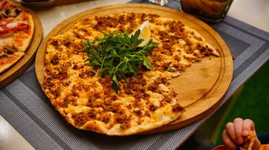 Kısmen yenmiş et, maydanoz ve limon dilimli Türk pizzası..
