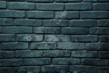 Koyu renkli bir tuğla duvarın yakın çekimi..