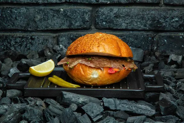 Limonlu ve biberli taze ızgara etli sandviç kömür yatağının üzerinde siyah bir ızgara üzerinde oturur..