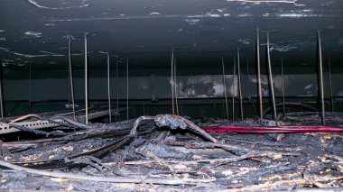 Kömürleşmiş elektrik kablolarının yakın çekimi ve yangından zarar görmüş bir tavan..