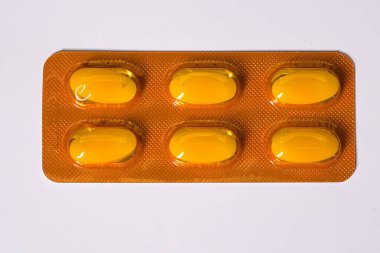 İçinde altı tane sarı hap olan bir paket, hepsi sağlam ve görünür..
