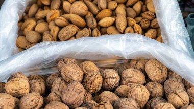 Badem ve ceviz yerel bir markette plastik poşetlerde satılmaktadır..