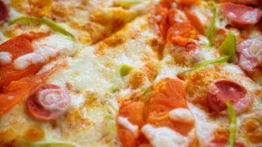 Biberli, yeşil biberli ve erimiş peynirli bir dilim pizza..