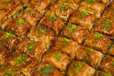 Şam fıstıklı bir tepsi baklava, şurupla parlayan yumuşak bir pasta..