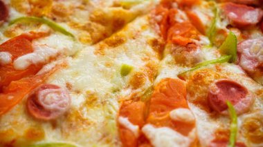 Eritilmiş peynir, pepperoni, yeşil biber ve pizza üzerine domates sosu..