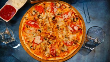 Tavuklu, mantarlı, domatesli ve peynirli bir pizza..