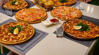 Dört pizza, iki bardak su, küçük bir tabak sos ve bir sepet patates kızartması..