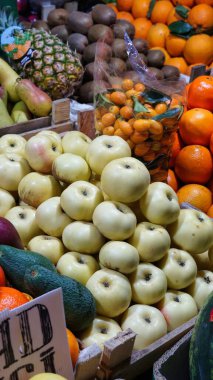 Bir markette, portakal, kivi ve ananas gibi diğer meyvelerle çevrili taze, beyaz elmalarla dolu ahşap bir sandığın yakın plan görüntüsü..