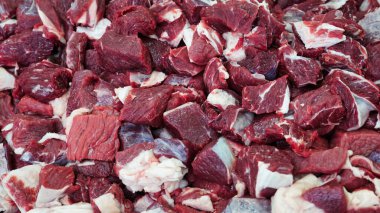 Pazar ortamında küp küp kesilmiş taze kırmızı et yığınının yakın görüntüsü..
