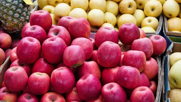 Bir markette üst üste yığılmış kırmızı elmaların yakın çekim görüntüsü.