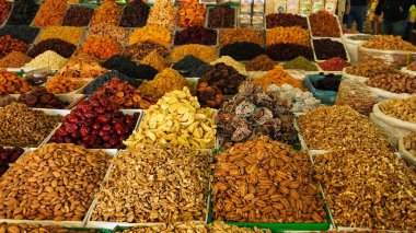 Kurumuş meyve ve fındık dolu renkli bir market müşteriler için çeşitli seçenekler sunuyor..