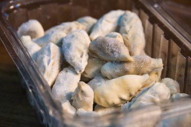 Plastik bir kabın içinde donmuş hamur köfteleri..