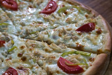 Tavuklu, domatesli ve yeşil biberli bir pizza..