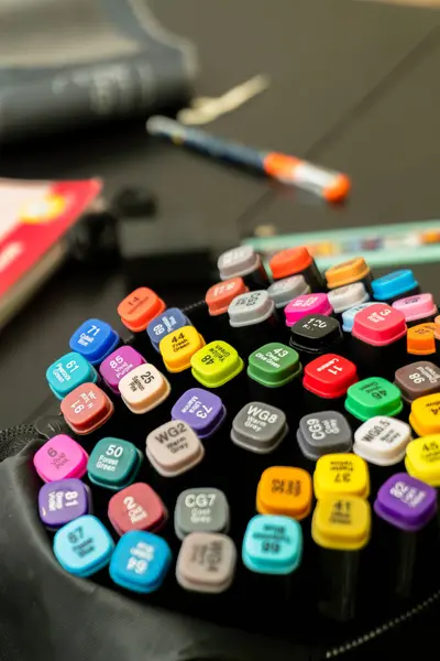 Hareketli bir kalem çeşidi düzgünce bir masanın üzerinde duruyor. Yakınlarda, defterler ve kalemler görünür, yaratıcılık ve üretkenlik atmosferi olduğunu gösteriyor..