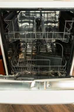 Inside view of an open dishwasher with empty racks, showcasing a clean interior ready for loading. The stainless steel finish adds a modern touch. clipart