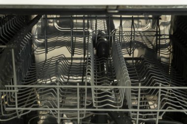 Modern bir bulaşık makinesinin içi paslanmaz çelik askı düzeni ve mutfak malzemelerini verimli bir şekilde temizlemek için kusursuz tasarımı var..