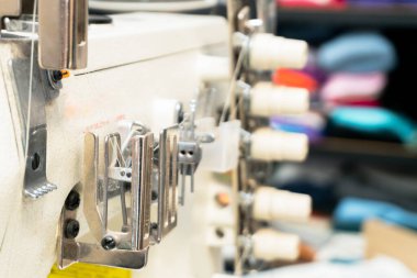 Endüstriyel dikiş makinesi etkin bir şekilde atölye ortamında kumaş dikiyor, karmaşık bileşenleri ve hassas aletlerini gösteriyor..