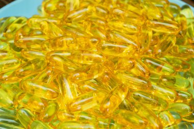 Mavi bir plakaya yayılmış sayısız parlak sarı kapsül parlak yüzeylerini ve eşsiz şekillerini gözler önüne sererek çarpıcı bir görsel karşıtlık yaratıyor..