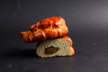 Altın kabuklu canlı bir somun ekmek dilimlenmiş bir parçanın üzerinde oturur ve içindeki zengin, tatlı dolguyu ortaya çıkarır. Karşıt renkler davetkar bir görünüm yaratır.