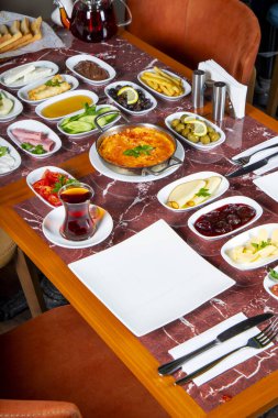 Geleneksel Türk kahvaltı öğeleri mermer bir masaya dizilmiştir..
