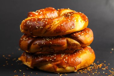 Üst üste istiflenmiş üç altın sarısı kraker cezbedici bir görüntü oluşturur. Yumuşak, parlak yüzey susam tohumları ve serpiştirilmiş baharatlarla dolu..