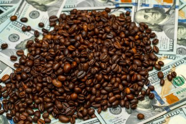 Koyu kavrulmuş kahve çekirdekleri, zenginlik ve popüler bir içecek arasındaki zıtlığı vurguluyor..