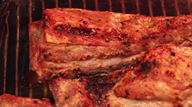 Kalın dilimler halinde ızgara et ızgarada cızırdıyor, altın kahverengi kabuk ve kömürleşmiş kenarları sergiliyor, yaz mangalları için ideal..