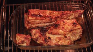 Lezzetli bir domuz rostosu yavaşça fırında pişiyor, içinde altın rengi kahverengi, çıtır çıtır ve sulu bir et sergiliyor. Aroması mutfağı dolduruyor..