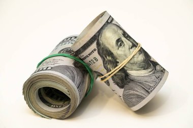 Plastik bantlarla korunan iki rulo para, banknotların detaylarını ve güvenli ambalajlarını vurgulamak üzere düz bir yüzeye yerleştirilmiştir..