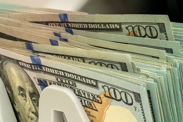 Yüz dolarlık banknotlar düzenli bir şekilde üst üste dizilmiş, servetlerini resmetmek için ideal, karmaşık tasarım ve güvenlik özelliklerini vurguluyor..