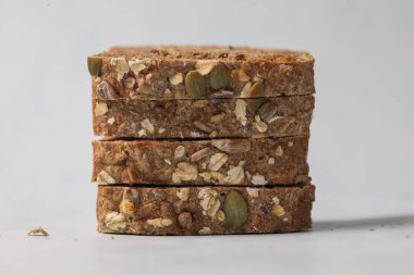 Tohumlar ve fındıklar içeren dört yulaf çubuğunun yakın plan görüntüsü, kahvaltı için ideal besleyici bir aperatif seçeneği sunuyor.