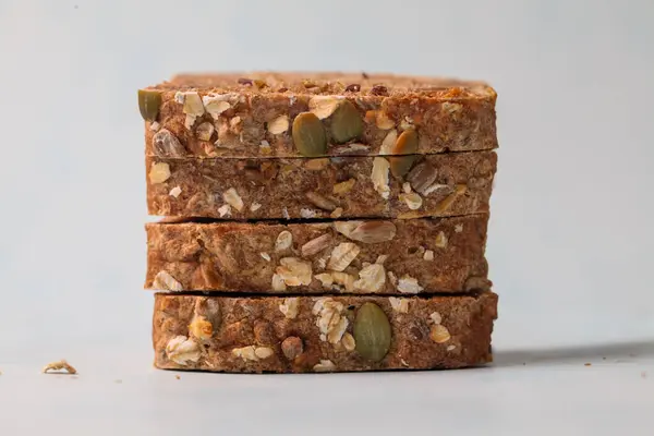 Tohumlar ve fındıklar içeren dört yulaf çubuğunun yakın plan görüntüsü, kahvaltı için ideal besleyici bir aperatif seçeneği sunuyor.