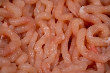 Bu yakın plan, pürüzsüz ve hafif parıltılı bir dokuya sahip taze deniz ürünlerini gösteriyor. Karmaşık iplikler yemek pişirmeye hazırlandığını vurguluyor..