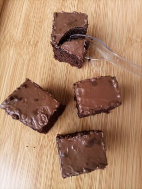 Çikolatalı browni dilimleri, zengin ve çürümüş, sanatsal olarak sade ahşap bir tepside sergilenir.