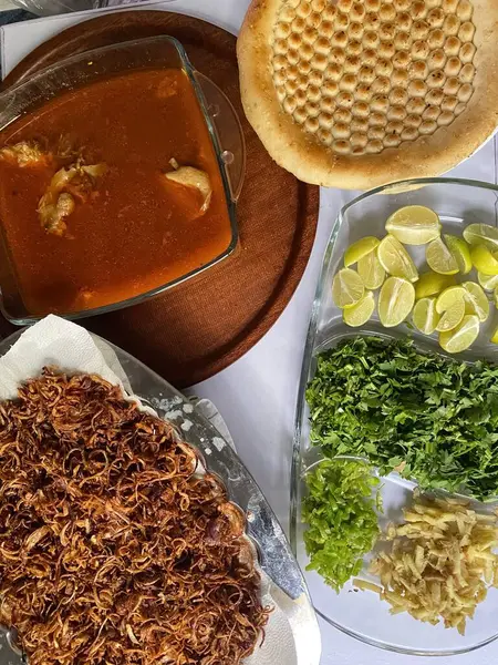 Nihari tavuğu, limon, kızarmış soğan, yeşil biber, zencefil ve taze kişniş ile servis edilir..
