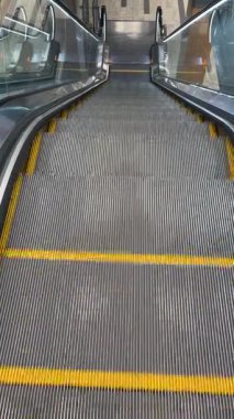 Metro istasyonunda aşağı doğru inen bir yürüyen merdivenin videosu. Toplu taşıma ve şehir temaları için mükemmel.