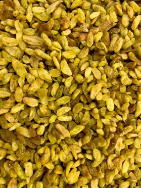  Kurutulmuş kuru üzümlerin tüm çerçeveyi doldurduğu yakın plan görüntüsü. Buruşuk dokuları ve koyu kahverengi tonları sağlıklı gıda kavramları, ambalaj tasarımı veya besinle ilgili içerik için mükemmel zengin, organik bir zemin oluşturur..